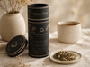 Milky Way Lactation Tea canister on a table with tea leaves and a cup.